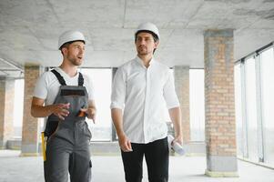 Engineer and worker checking project at building site background, construction site at sunset in evening time photo