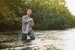 Fisherman hunting trouts in mountain river. Fishing net detail. photo