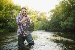 Fishing. Fisherman and trout. Fisherman on wild river. photo