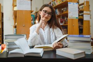 educación, alto escuela, universidad, aprendizaje y personas concepto. sonriente estudiante niña leyendo libro foto