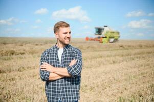 Farmer Standing In Wheat Field At Harvest photo