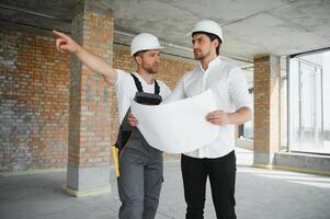 View of a Worker and architect watching some details on a construction photo