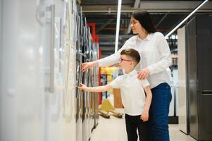 family uying domestic refrigerator in supermarket photo