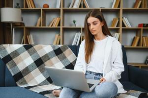 Full length portrait of cheerful charming person sit hold netbook browsing have good mood working home indoors photo