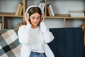 Girl with a laptop and headphones listens to music. photo