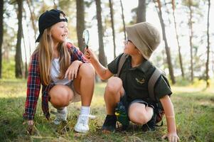 niños explorador naturaleza con aumentador vaso. verano actividad para inquisitivo niño. foto