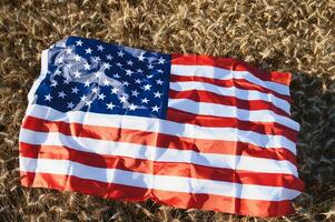 Estados Unidos americano bandera esparcido en el dorado trigo campo. foto