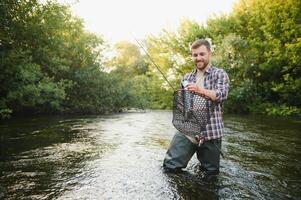 joven hombre pesca con mosca a amanecer foto