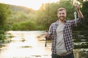 Fly-fisherman holding trout out of the water photo