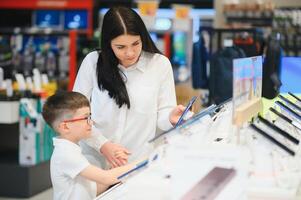 mujer con hijo en Tienda comprando nuevo teléfono. foto