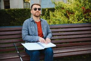 Blinded man reading by touching braille book photo