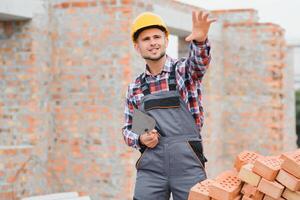 Construction worker in uniform and safety equipment have job on building. Industrial theme photo