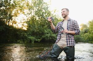 Male hobby. Ready for fishing. Relax in natural environment. Trout bait. Bearded elegant man. Man relaxing nature background. Strategy. Hobby sport activity. Activity and hobby. Catching and fishing photo