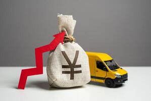 Delivery van and chinese yuan or japanese yen money bag with red arrow up. Transport industry. Increased profits when delivering online orders. Trade and sale of goods. Online shopping. photo