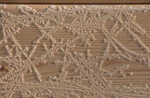 Brown wood texture with white frost patterns. Winter background. photo