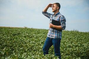 joven agricultor en campos de soja foto