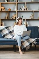 Full length portrait of cheerful charming person sit hold netbook browsing have good mood working home indoors photo