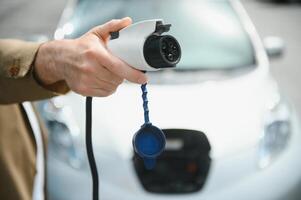 Man holding power connector for electric car photo
