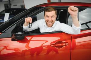 contento hombre demostración el llave de su nuevo coche. foto