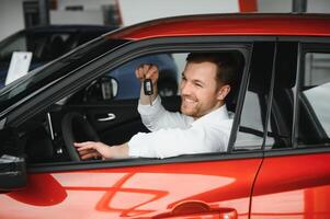 Happy man showing the key of his new car. photo