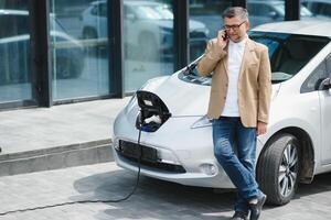 un empresario cargos un eléctrico coche foto