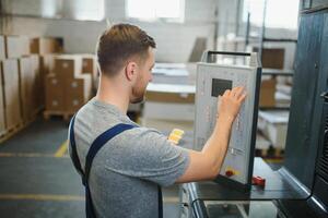 Man working in printing house with paper and paints photo