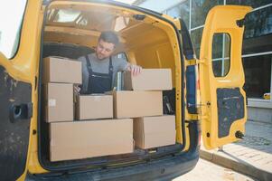 Delivery men unloading moving boxes from car photo