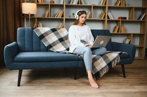 Full length portrait of cheerful charming person sit hold netbook browsing have good mood working home indoors photo