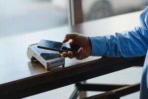 Mature businessman paying with contactless credit card with NFC technology. photo