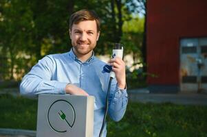 Man Holding Power Charging Cable For Electric Car. photo