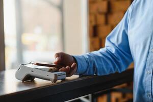 Mature businessman paying with contactless credit card with NFC technology. photo