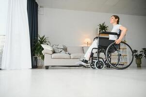 Young woman in wheelchair at home photo