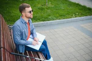 Blind man reading book on bench in park photo