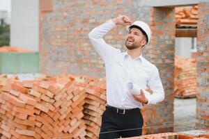 Architect at a construction site with blueprints photo