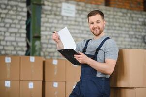 Warehouse worker carrying a carton for delivery to production stock. photo