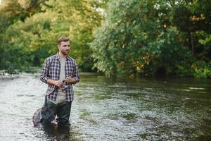 joven hombre pesca con mosca a amanecer foto