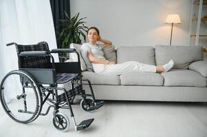 mujer molesto a sentar abajo en silla de ruedas desde sofá foto