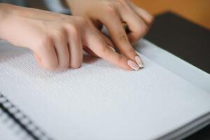 Blind woman read book written in Braille photo