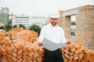 Architect at a construction site with blueprints photo