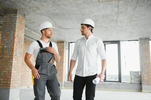 View of a Worker and architect watching some details on a construction photo