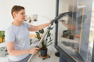 Middle-aged woman cleaning new apartment. photo