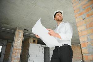 Close up engineers working on a building site holding a blueprints.Engineering and architecture concept photo