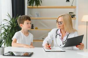 cuidado de la salud para niños pequeño chico hablando a médico durante visitar a hospital. foto