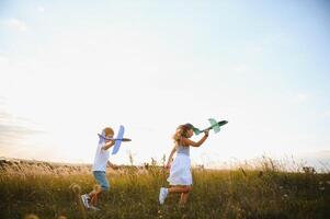 Active running kids with boy holding airplane toy. photo