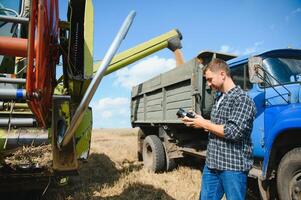 Farmer Standing In Wheat Field At Harvest photo