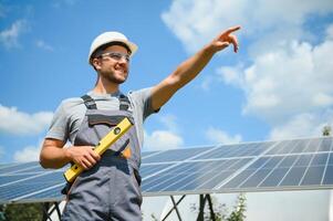 Male engineer in protective helmet installing solar photovoltaic panel system. Alternative energy ecological concept. photo