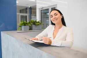 morena mujer recepcionista trabajando en recepción de el belleza salón. foto