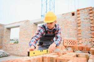 trabajador de la construcción en uniforme y equipo de seguridad tiene trabajo en la construcción foto