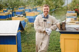 un herramientas de el apicultor. todo para un apicultor a trabajo con abejas. fumador, un cincel, un caja, apicultor traje para proteccion desde el abejas, equipo para apicultura, apicultura concepto foto