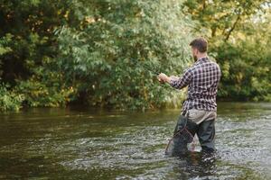 Fisherman hunting trouts in mountain river. Fishing net detail. photo